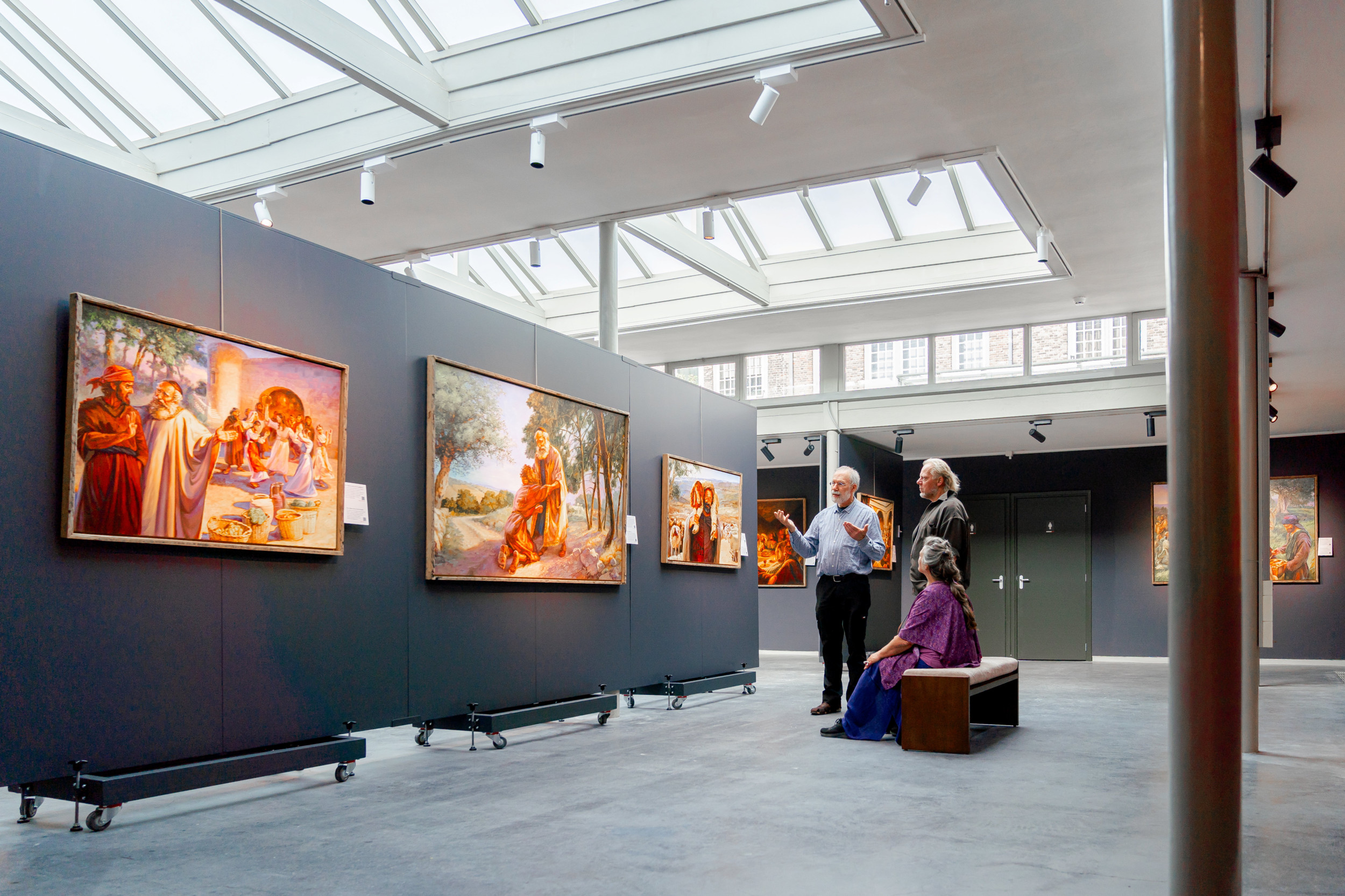 Kunstenaar Jan van ’t Hoff en bezoekers van de tentoonstelling ”Het Woord in beeld” bij het schilderij ”De verloren zoon”. beeld Renate Bleijenberg-van Leeuwen