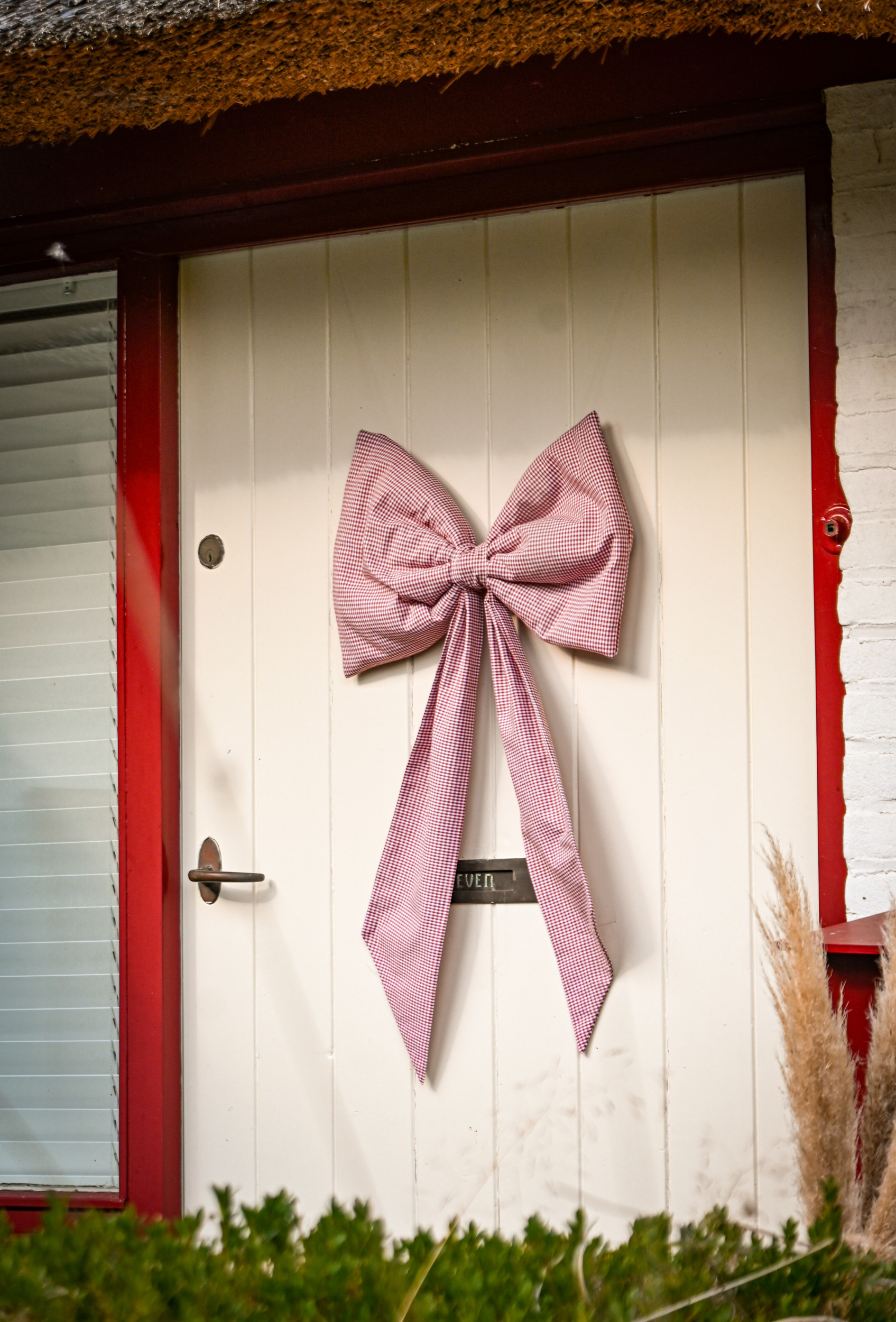 Grote strik van ruitjesstof op een voordeur