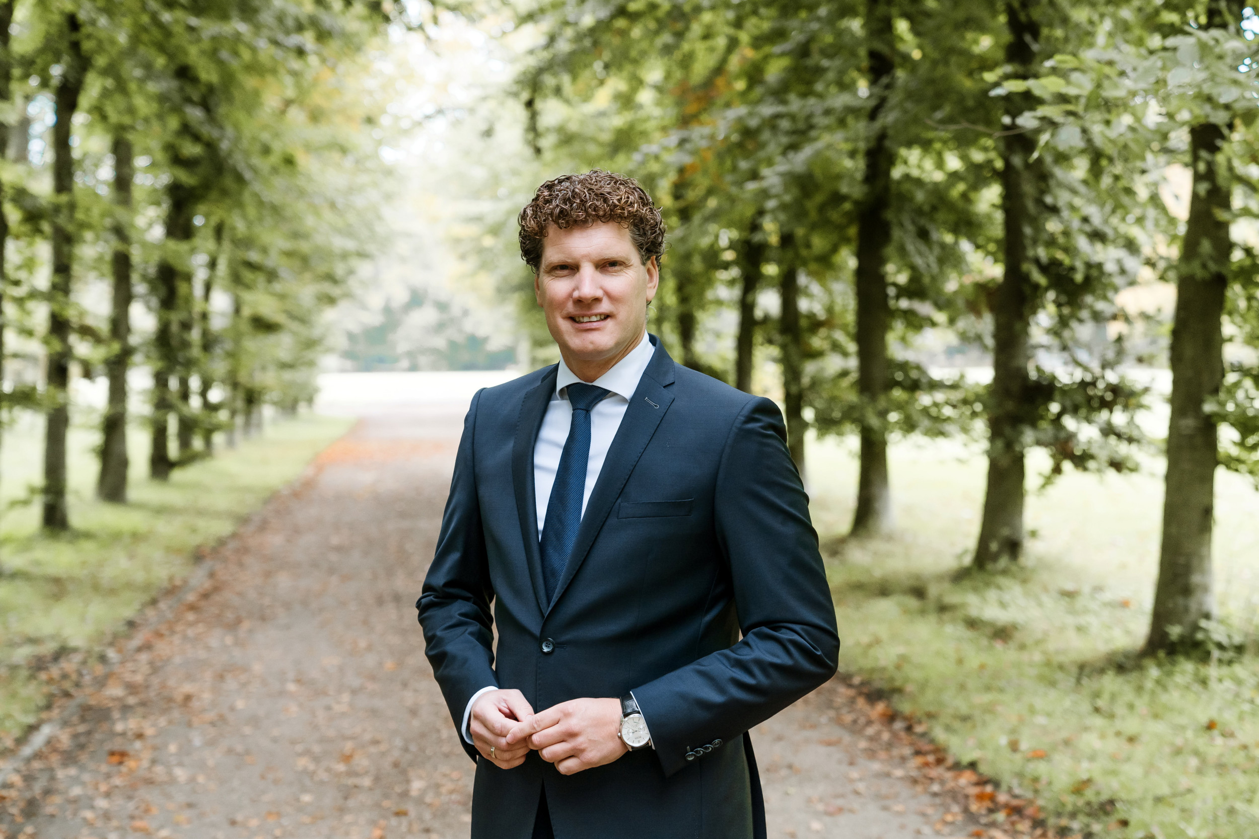 MAN IN BLAUW PAK IN EEN OPRIJLAAN 