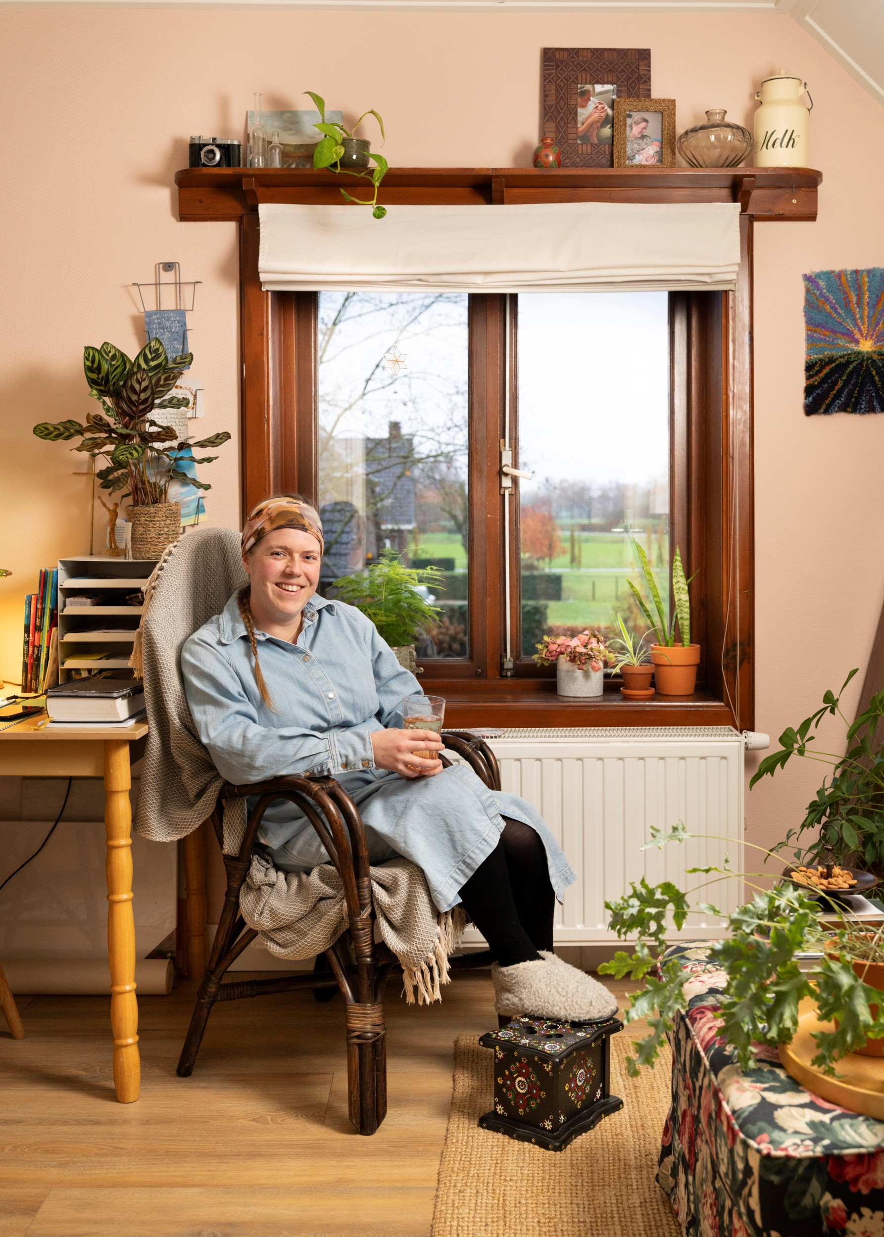 Een jonge vrouw zit op een stoel in een woonkamer.