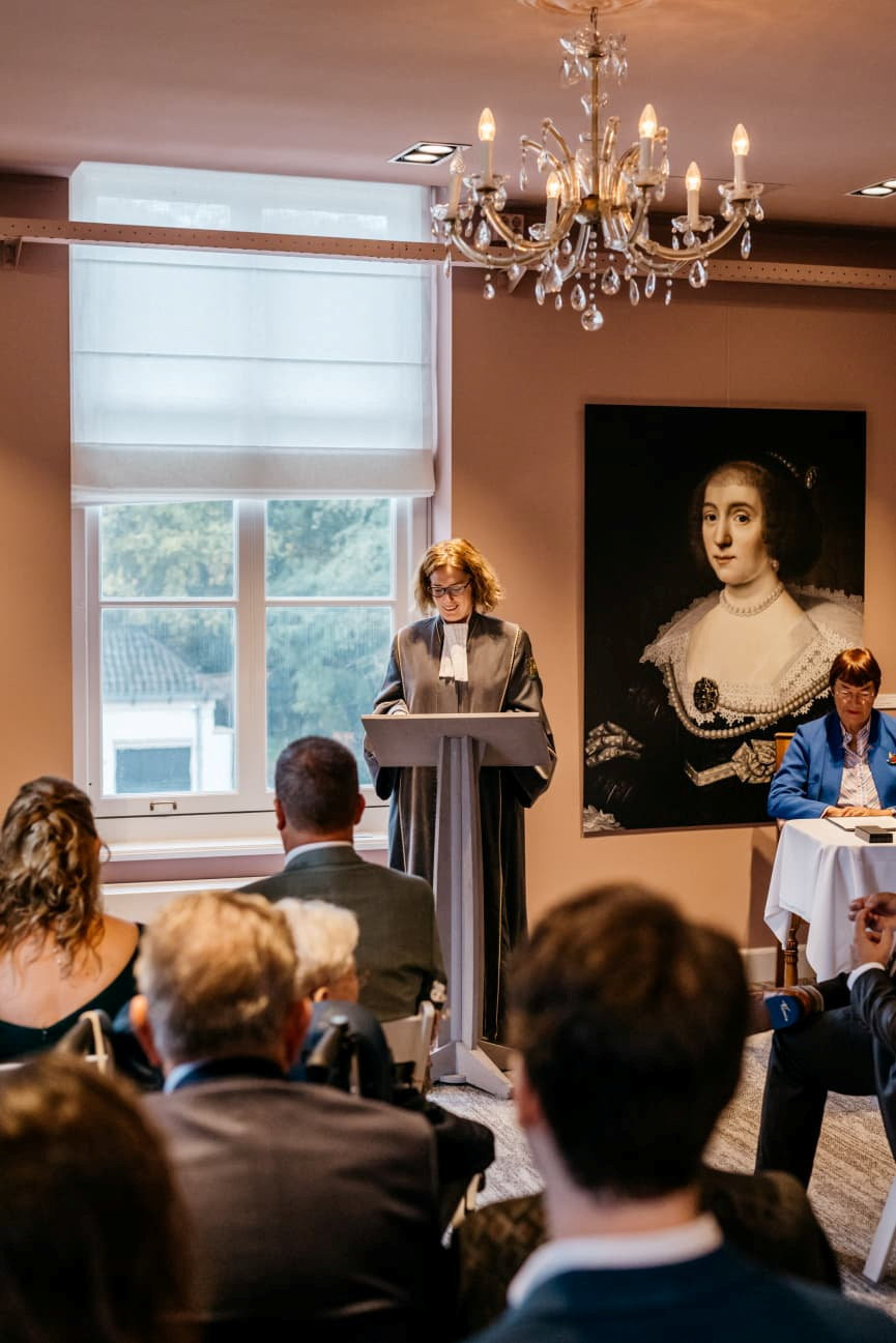 Judith Klokkenburg staat voor een katheder en leest de toespraak voor die ze schreef voor het huwelijk van Frank en Elisa van Vliet.