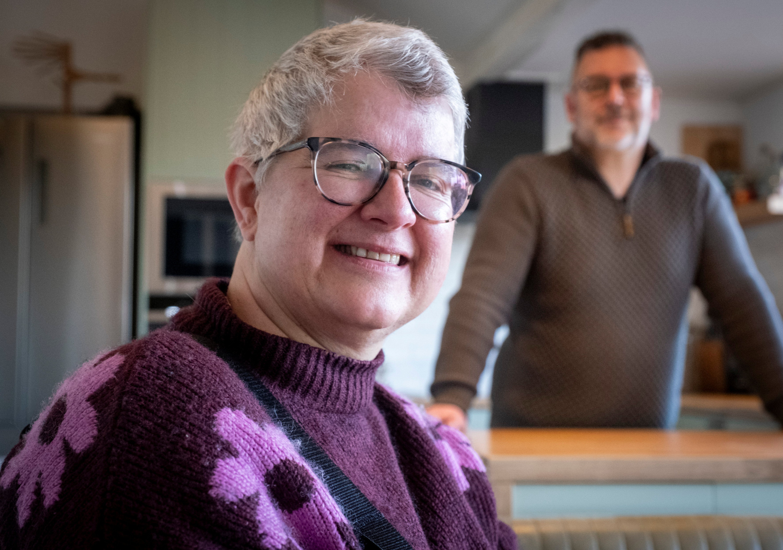 Colinda Verhoeven in de keuken van haar woning. Haar man Robert staat op de achtergrond.