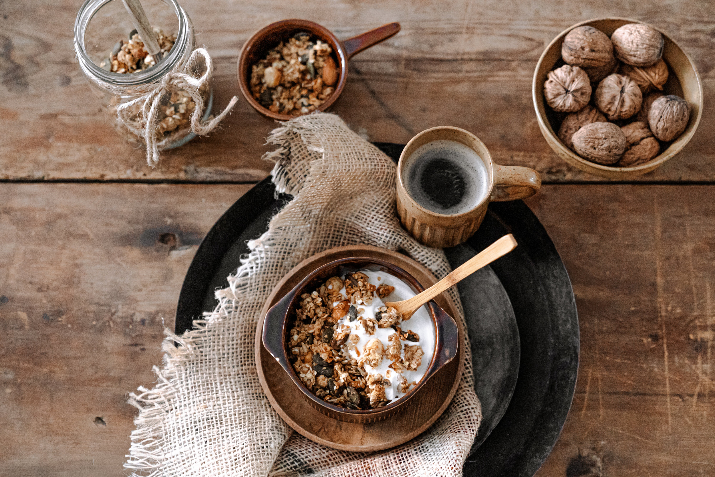 Schaal met granola en een kop koffie op een dienblad.
