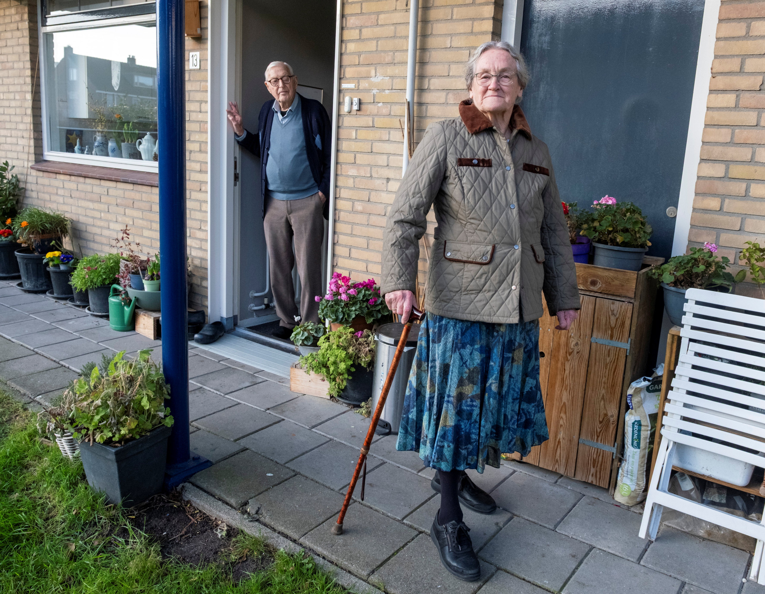 Jaap Saane staat in de deur van hun seniorenwoning terwijl hij zijn vrouw Willy uitzwaait.