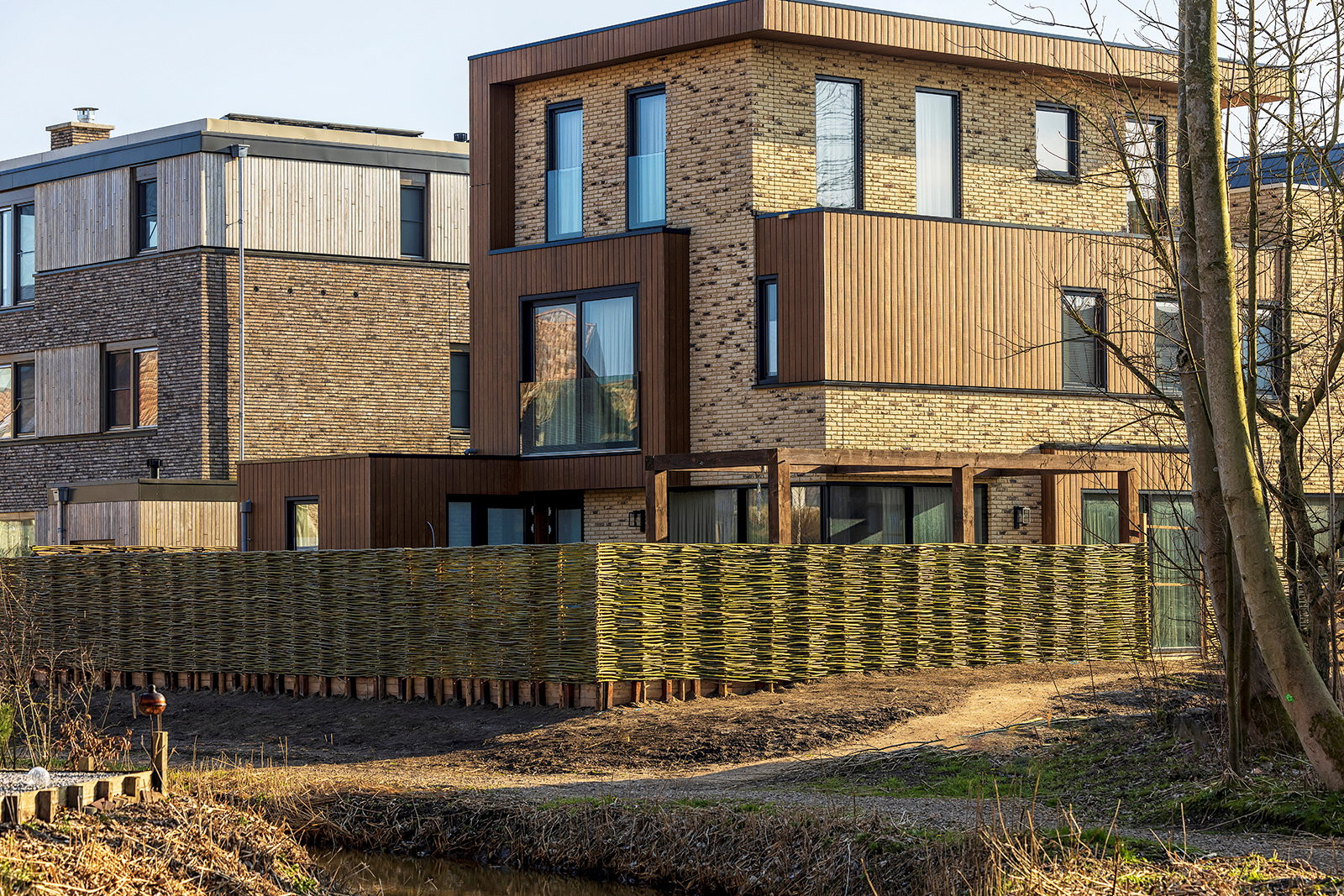 Wilgentenen schuttingen rondom een moderne villa