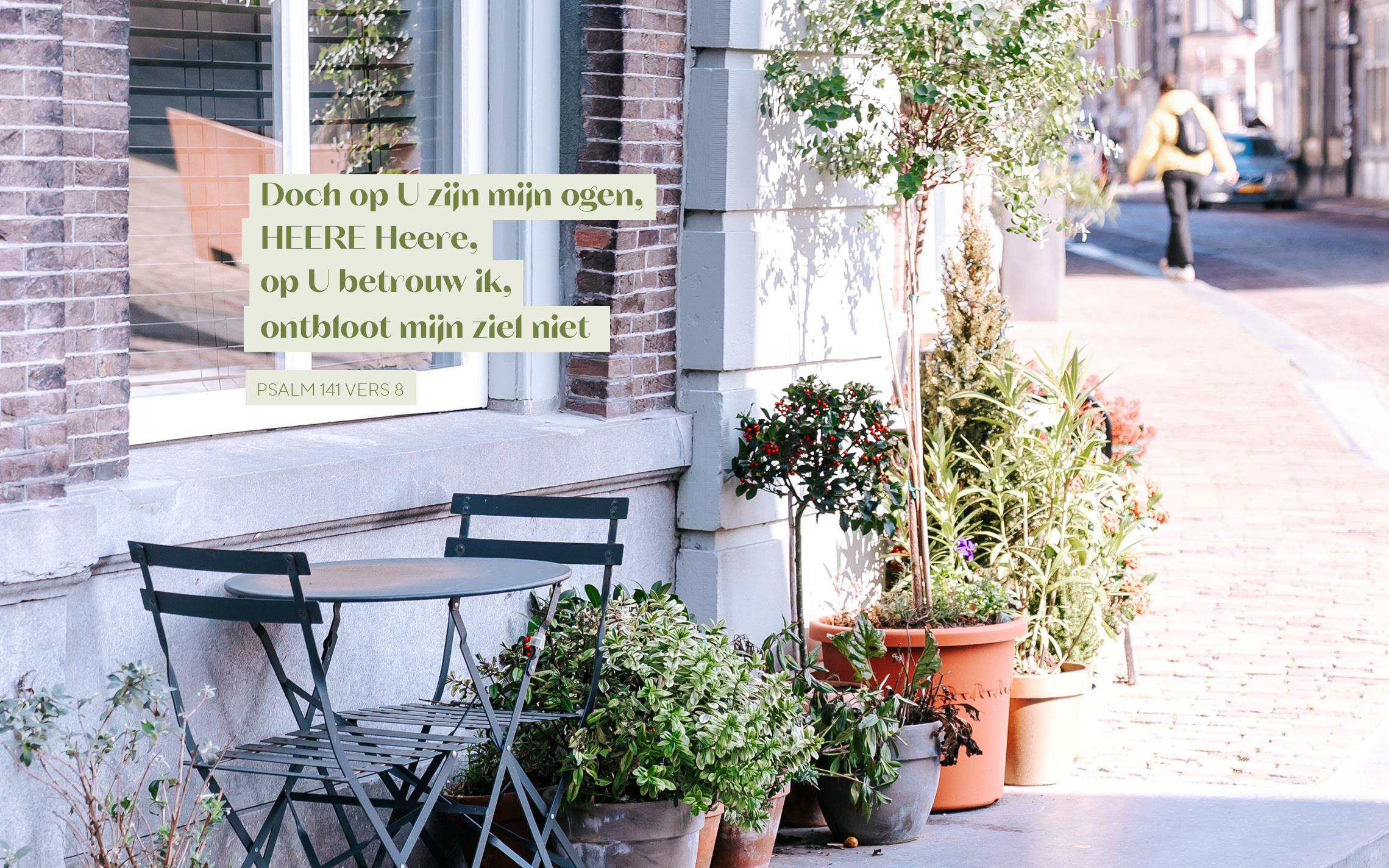 Een tafeltje met twee stoeltjes en daarnaast planten op een stoep, met eroverheen de tekst uit Psalm 141 vers 8: „Doch op U zijn mijn ogen, HEERE Heere, op U betrouw ik, ontbloot mijn ziel niet.”