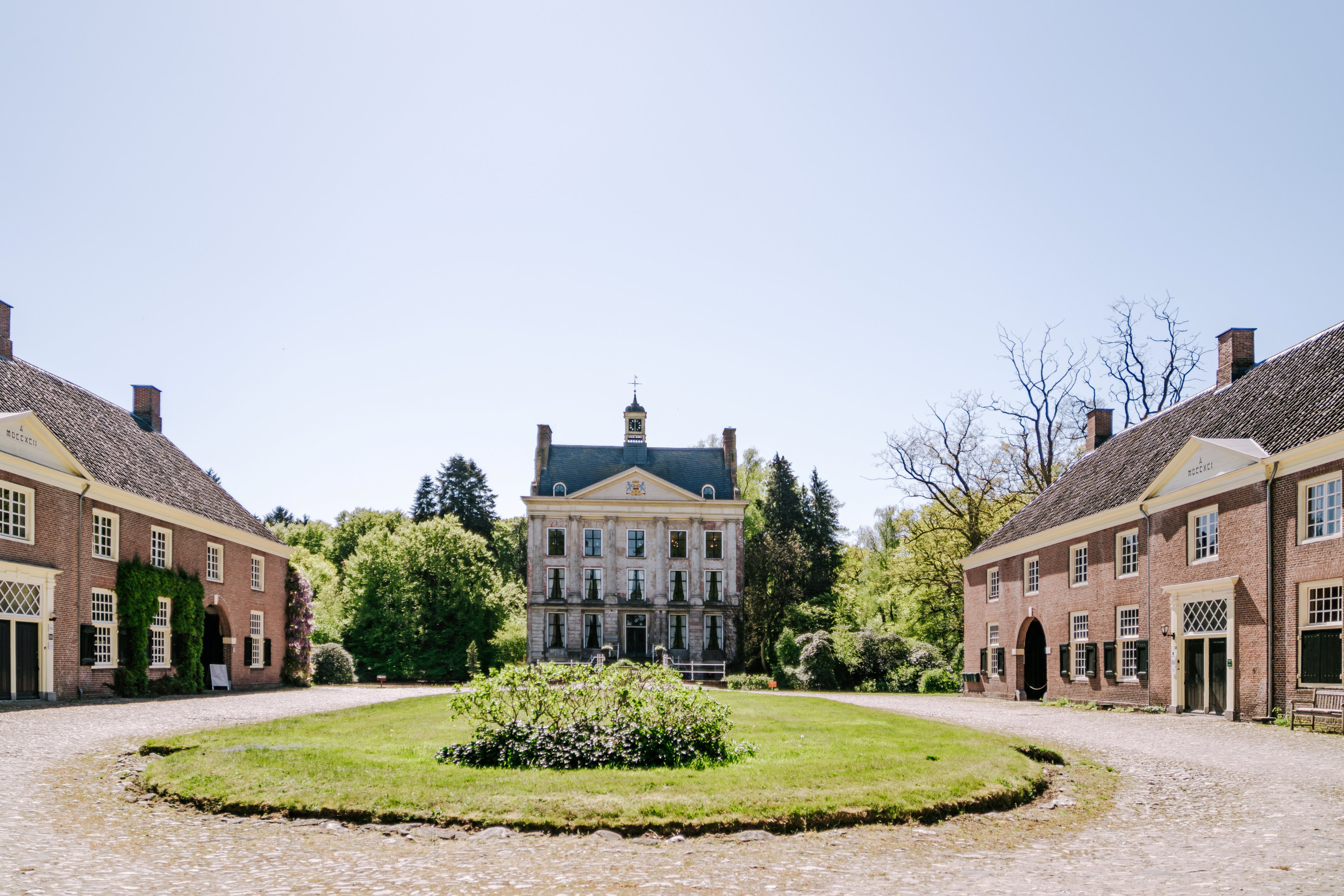 Landhuis met ervoor twee oude koetshuizen.