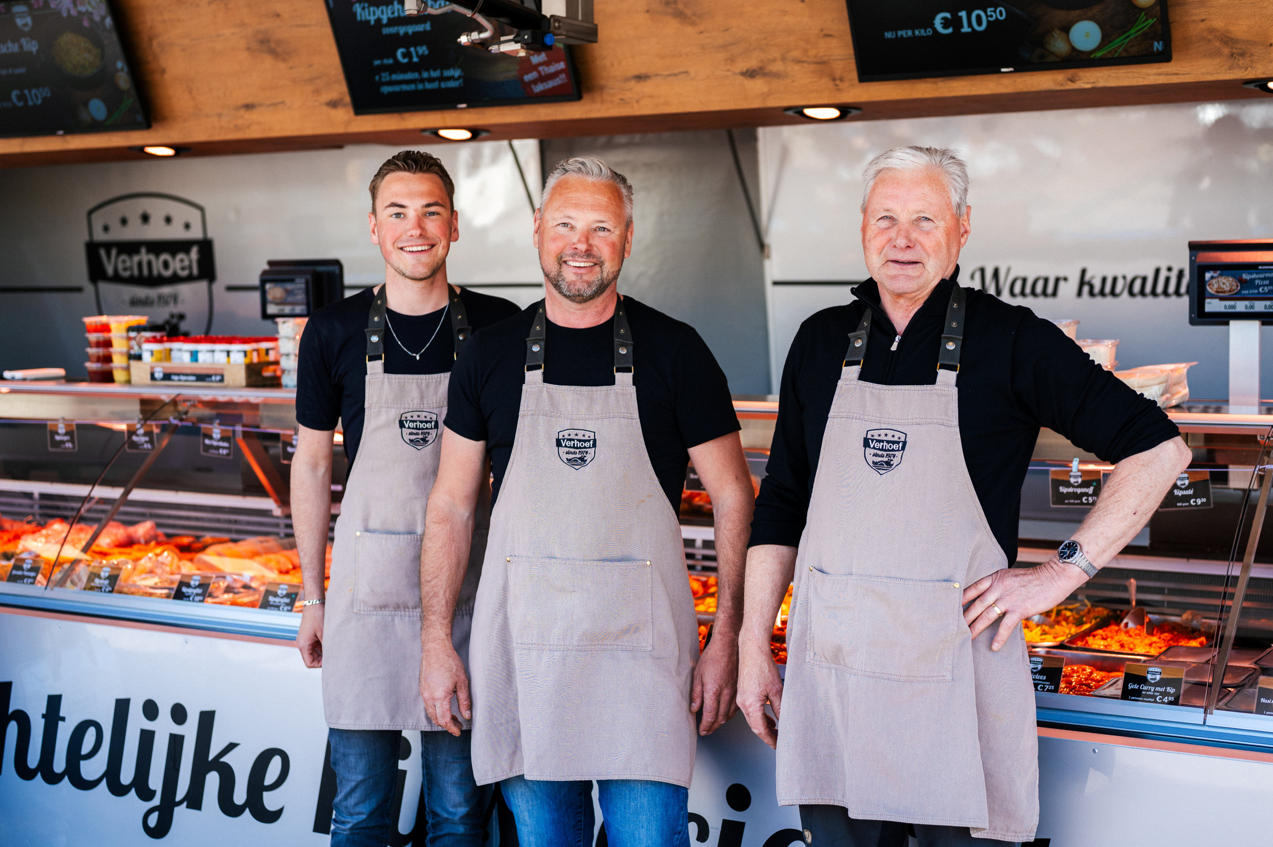 Drie generaties poeliers Verhoef staan voor de vitrine van hun polierswagen.  V.l.n.r.: Philip junior, Gert-Jan en Philip senior.