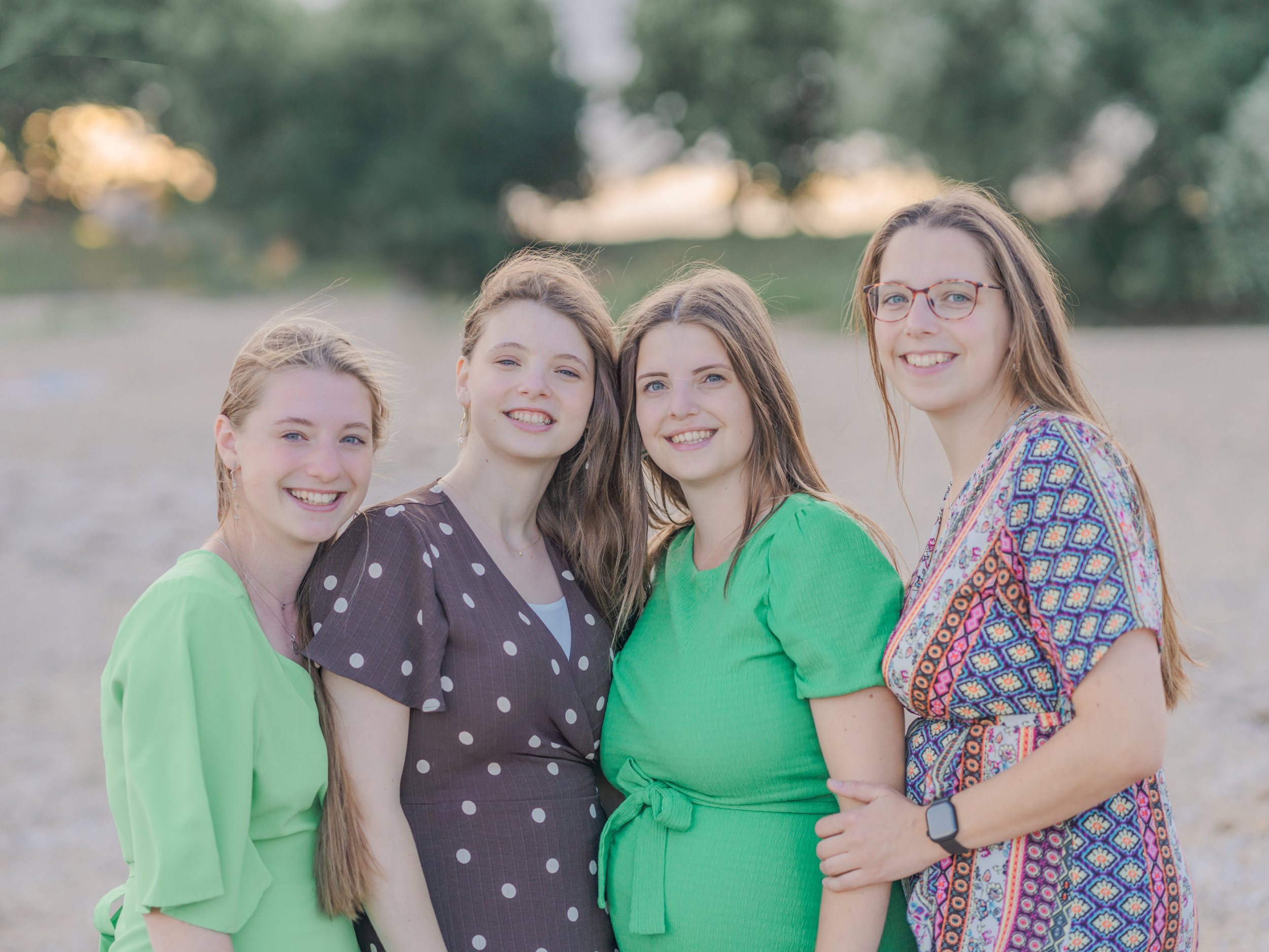 Vier jonge vrouwen op een rij; alle drie met lang, donkerblond haar. De rechtervrouw draagt een bril.