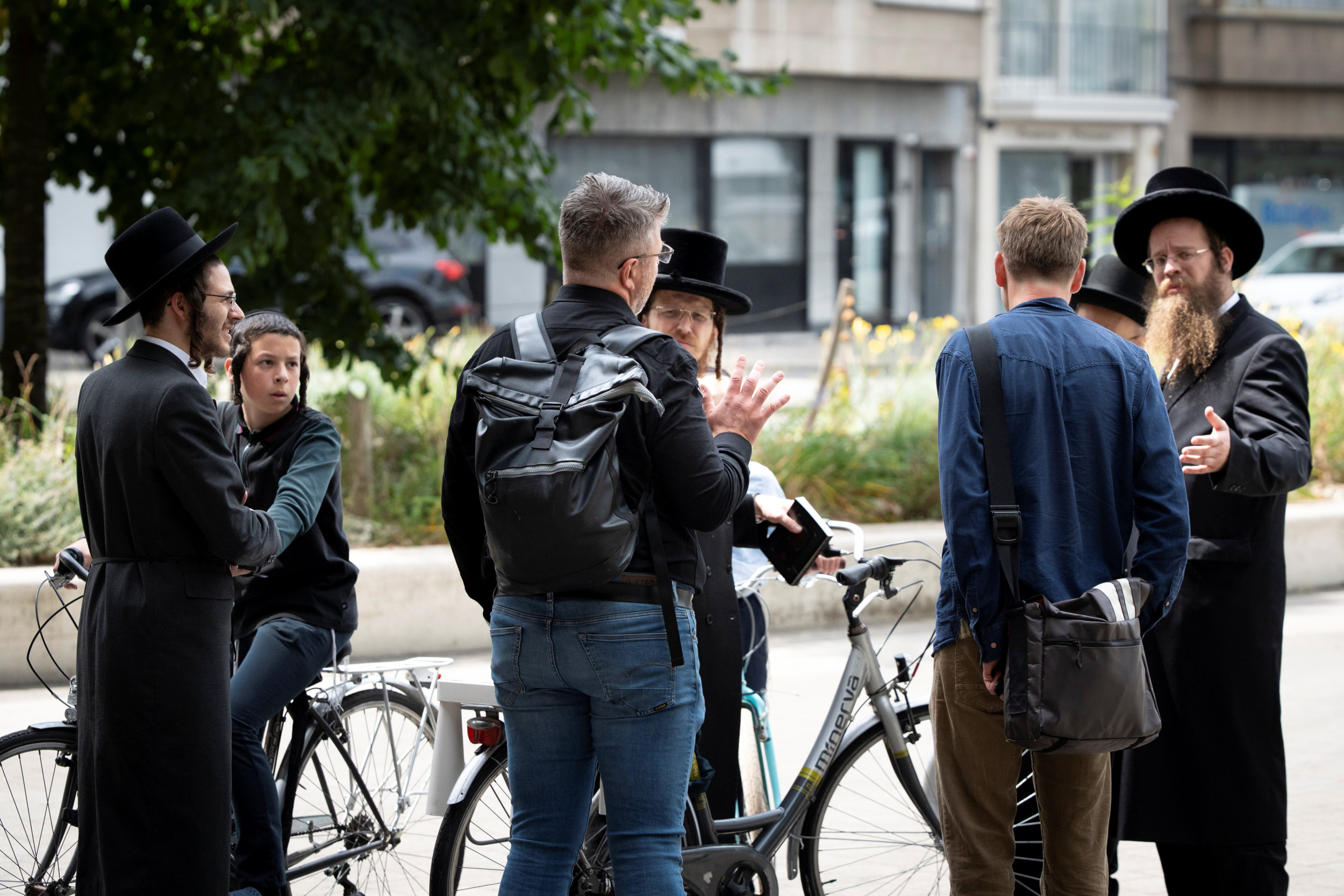Twee jonge mannen in gesprek met orthodoxe Joden.