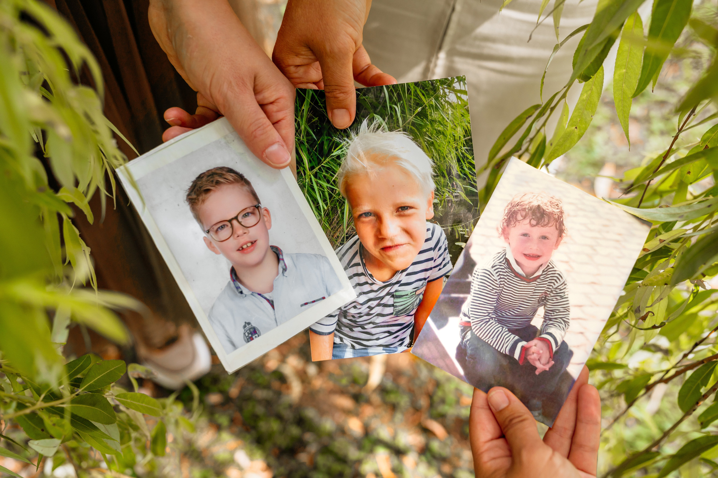Drie foto’s van drie jongetjes, vastgehouden door drie handen. (Van links naar rechts de foto’s van Jarko, David en Ruben.)