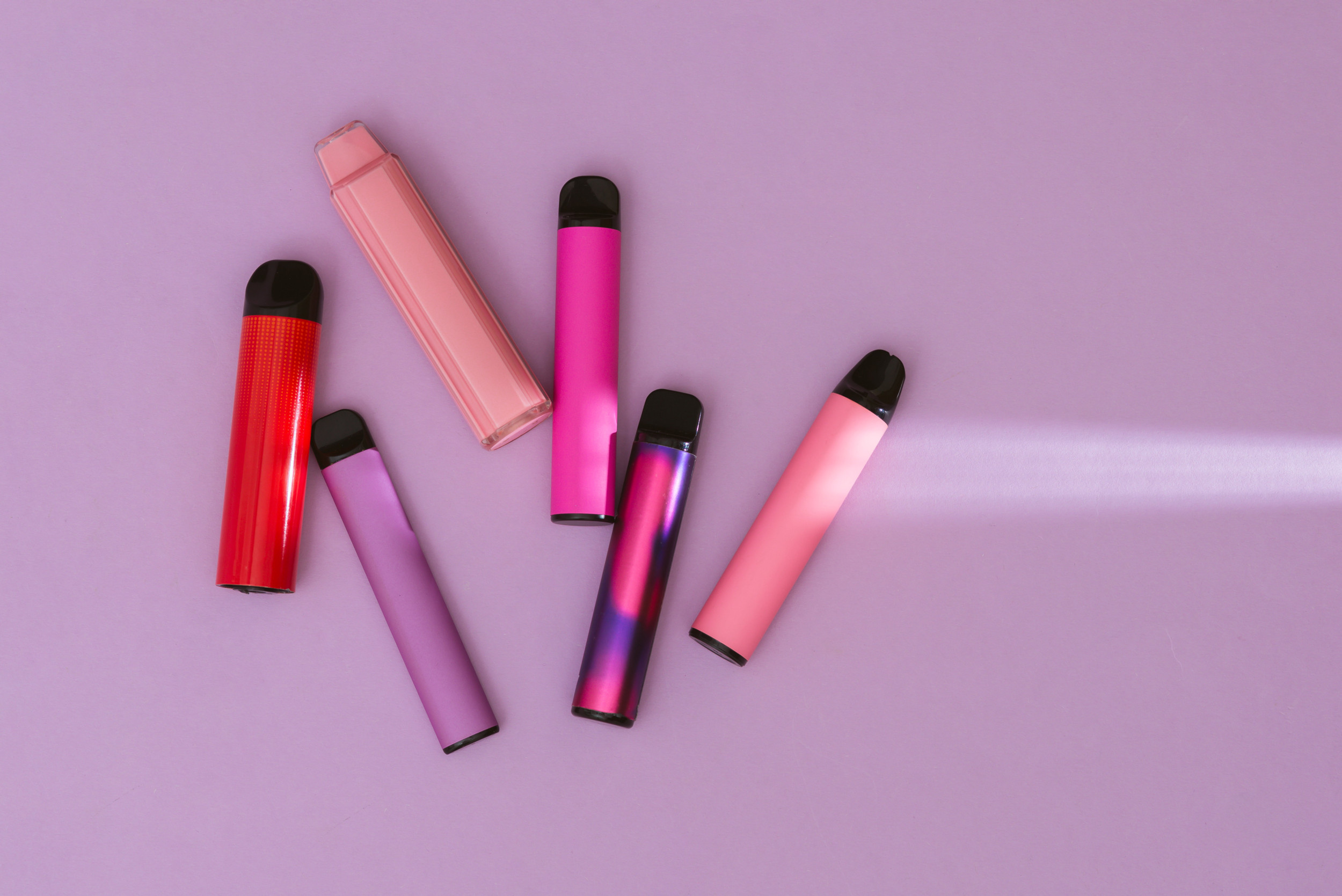 Vapes op een roze achtergrond.