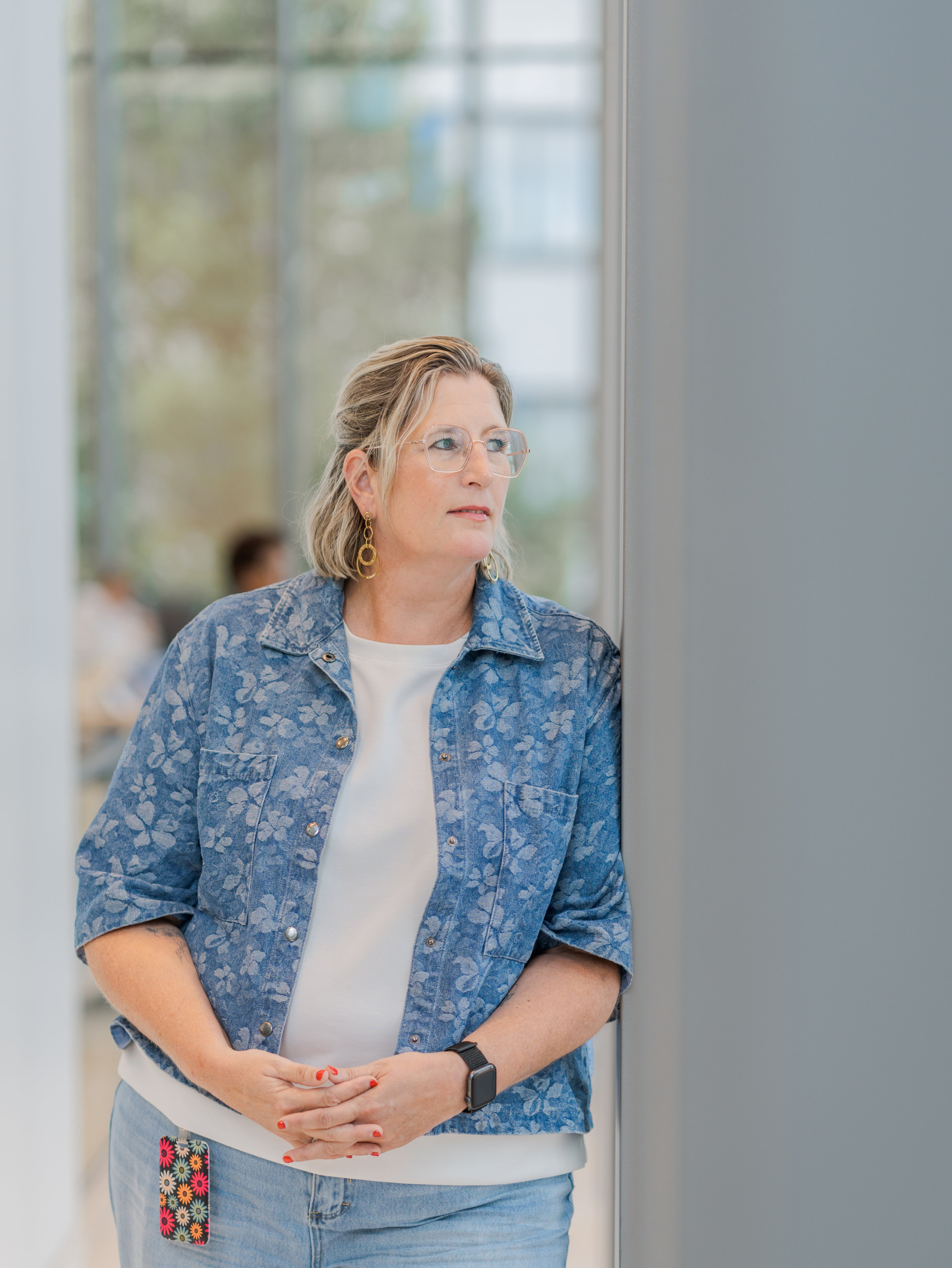 Vrouw in blauw jasje met bloemenprint.